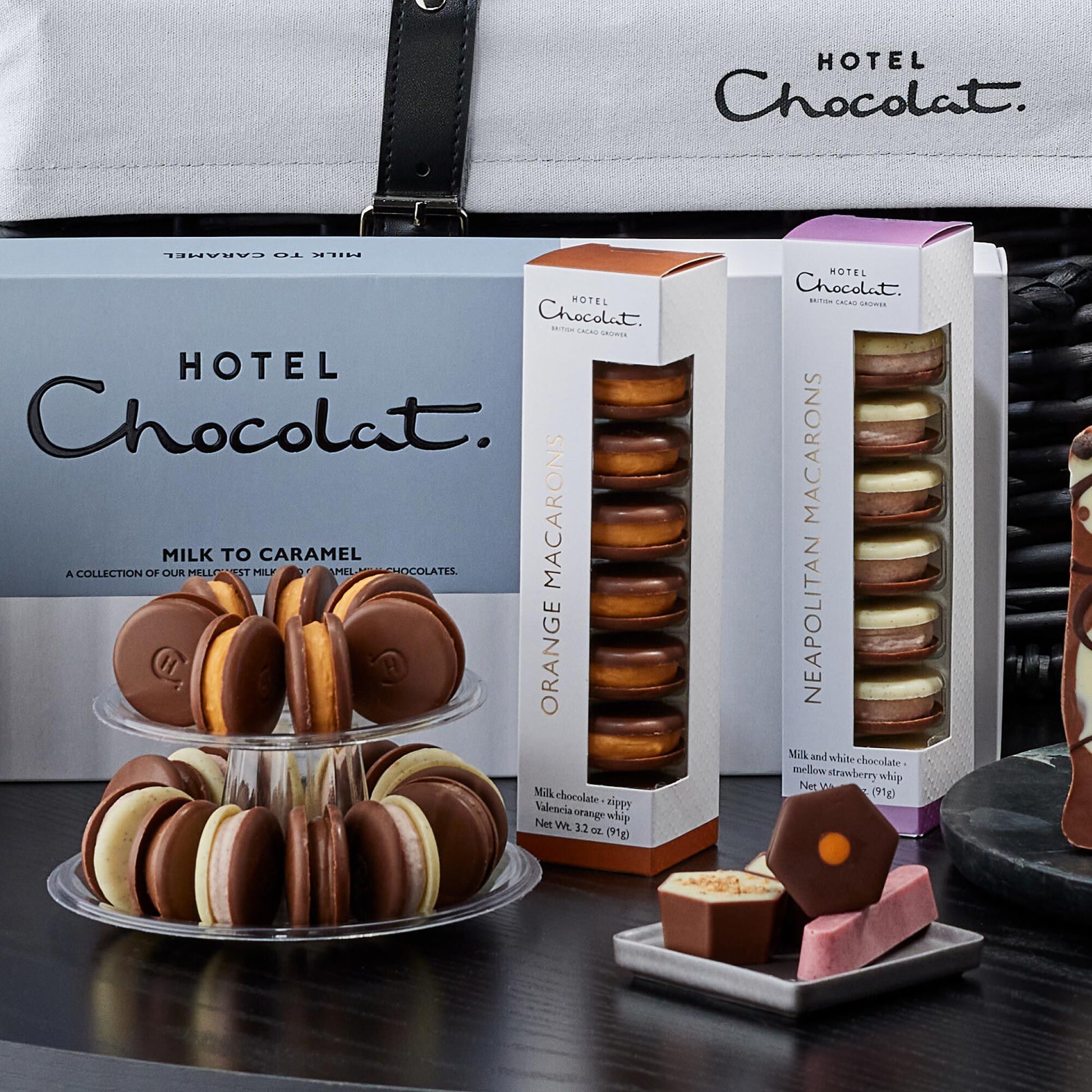 Hotel Chocolat macaron display with packaging on a dark surface