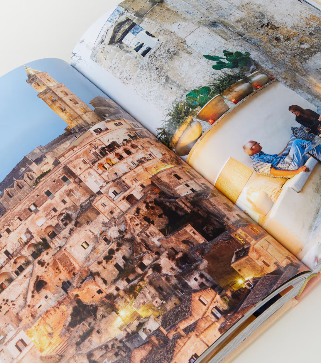 Open book showing images of a cityscape and people sitting outdoors.