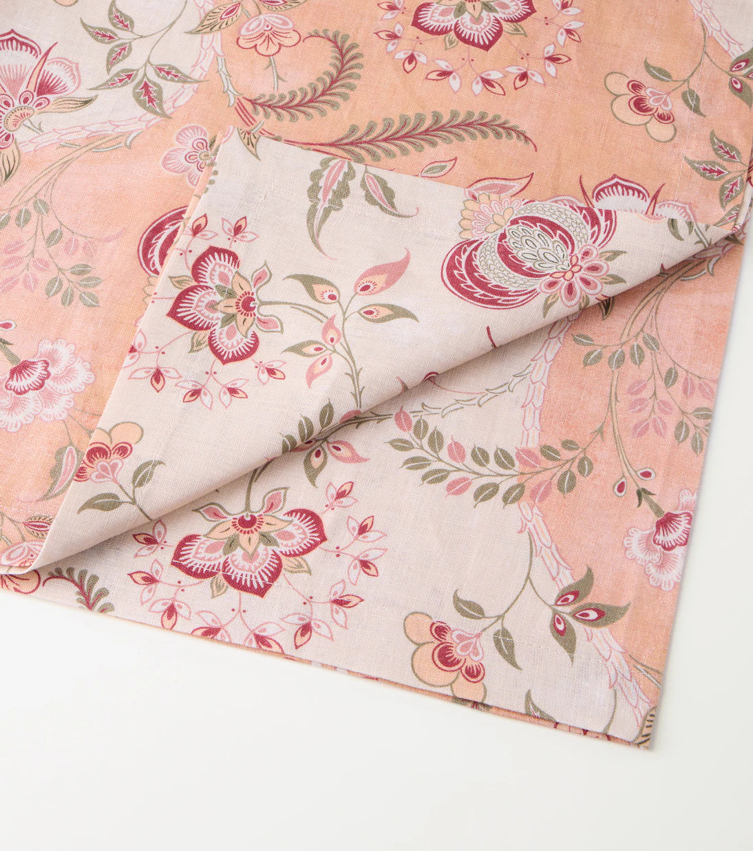 Floral fabric with pink and green patterns on a white background