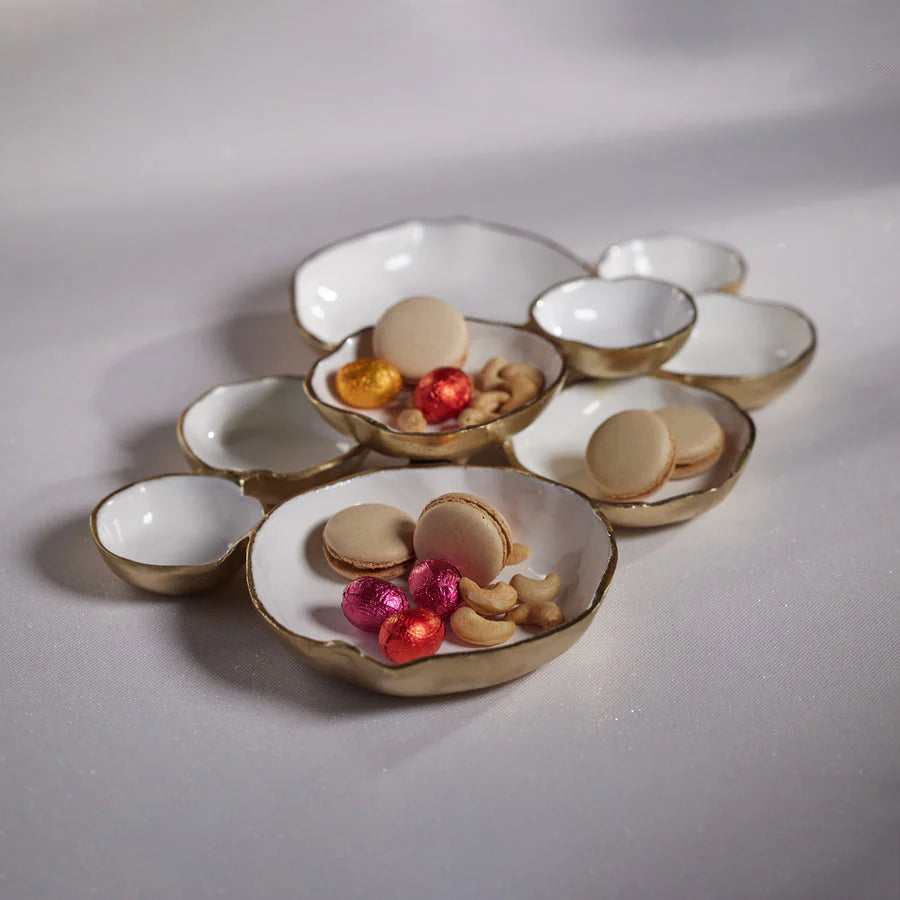 Set of small ceramic bowls with decorative items on a plain background